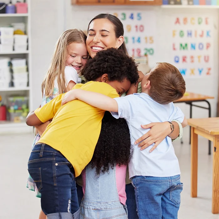 A teacher sharing a warm moment with children in a classroom
